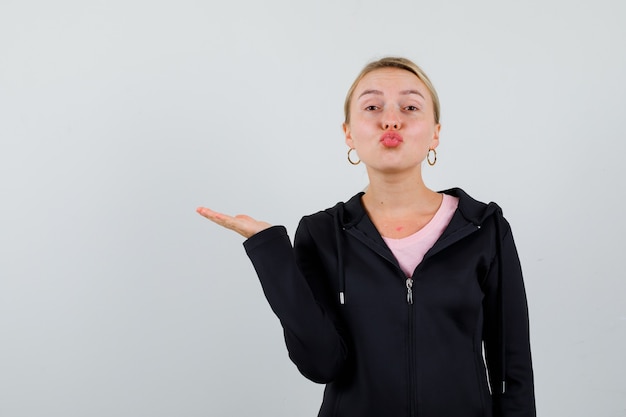 Jonge blonde vrouw in een zwarte jas