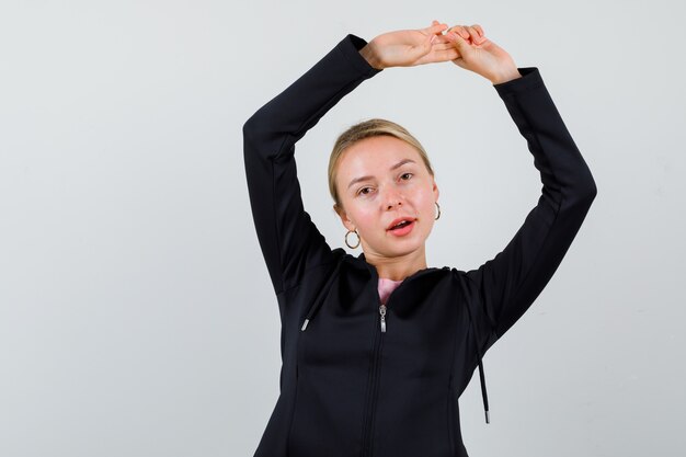 Jonge blonde vrouw in een zwarte jas