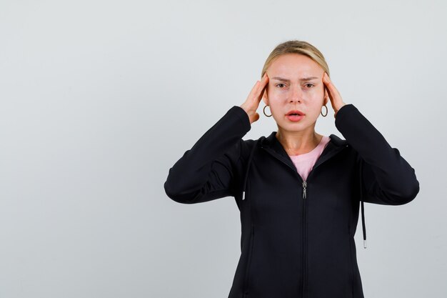 Jonge blonde vrouw in een zwarte jas