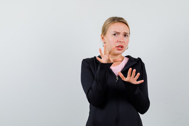 Jonge blonde vrouw in een zwarte jas