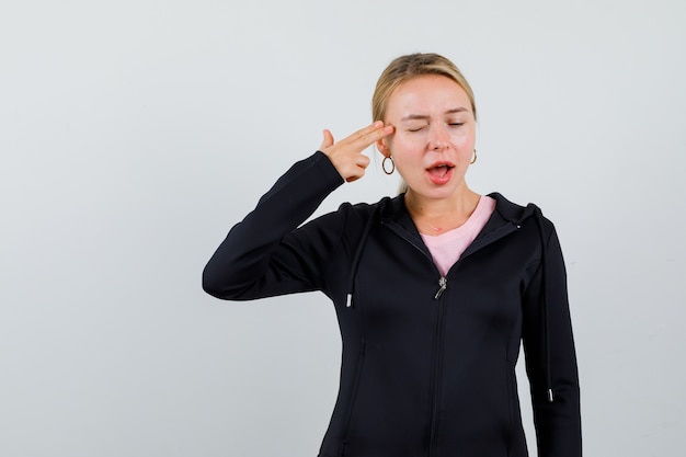 Jonge blonde vrouw in een zwarte jas