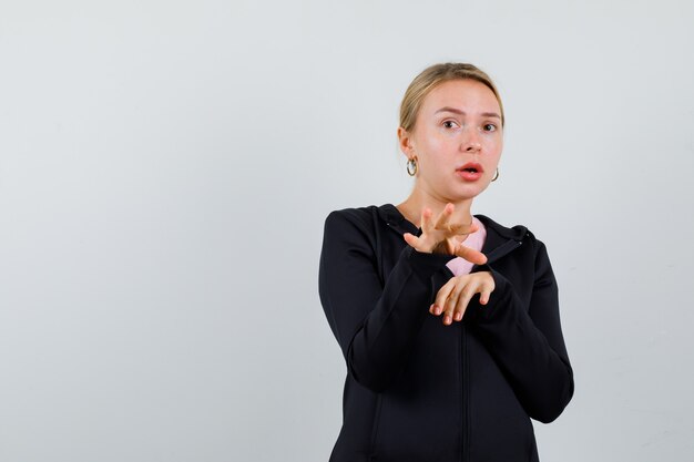 Jonge blonde vrouw in een zwarte jas