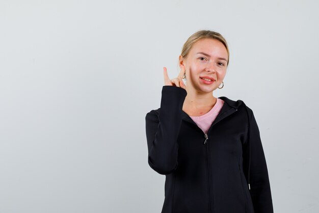 Jonge blonde vrouw in een zwarte jas