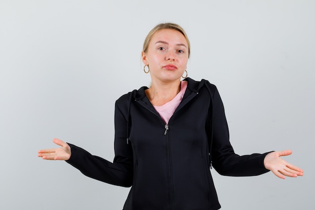 Jonge blonde vrouw in een zwarte jas