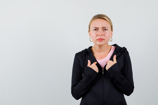 Jonge blonde vrouw in een zwarte jas