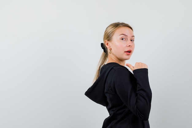 Jonge blonde vrouw in een zwarte jas