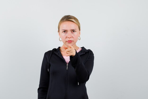 Jonge blonde vrouw in een zwarte jas