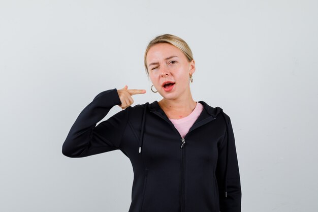 Jonge blonde vrouw in een zwarte jas