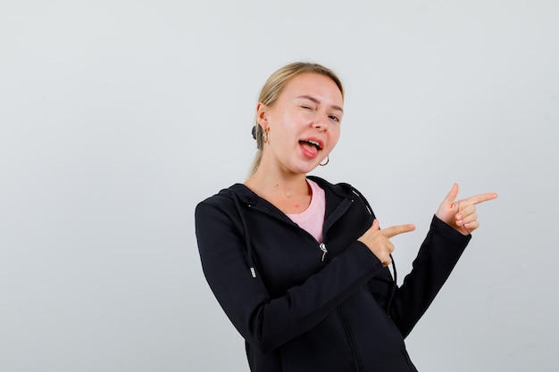 Jonge blonde vrouw in een zwarte jas