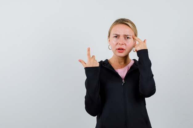 Jonge blonde vrouw in een zwarte jas