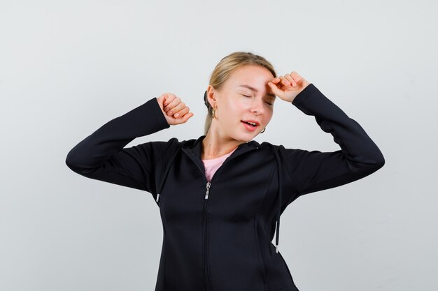 Jonge blonde vrouw in een zwarte jas