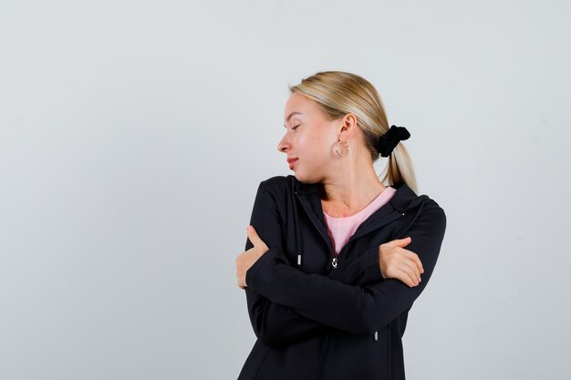 Jonge blonde vrouw in een zwarte jas