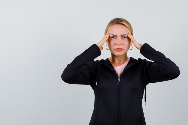 Jonge blonde vrouw in een zwarte jas