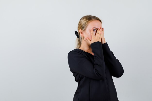 Jonge blonde vrouw in een zwarte jas