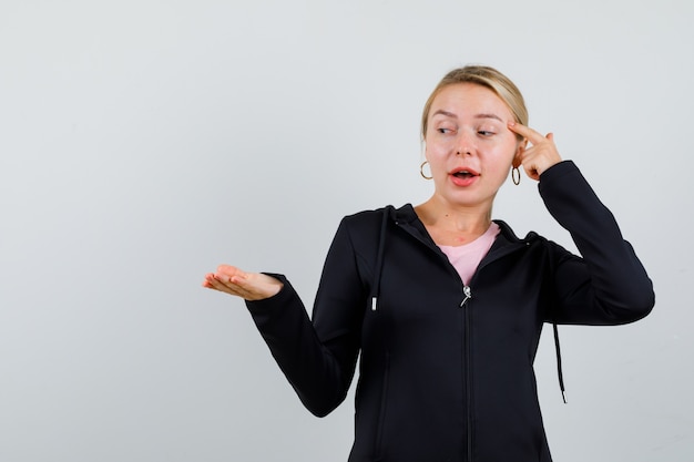 Jonge blonde vrouw in een zwarte jas