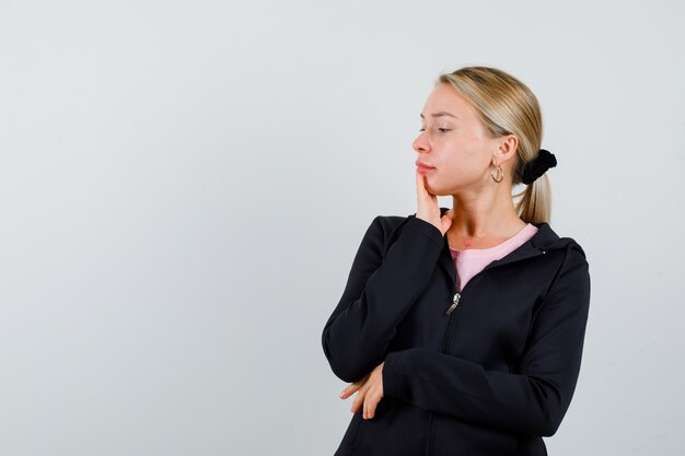 Jonge blonde vrouw in een zwarte jas