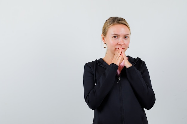 Jonge blonde vrouw in een zwarte jas