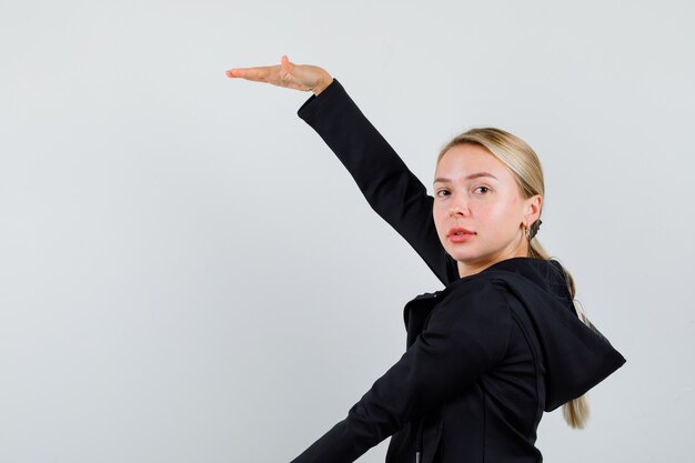 Jonge blonde vrouw in een zwarte jas