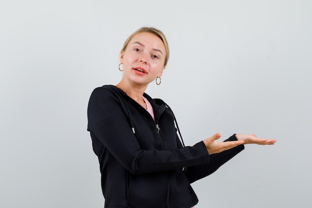 Jonge blonde vrouw in een zwarte jas