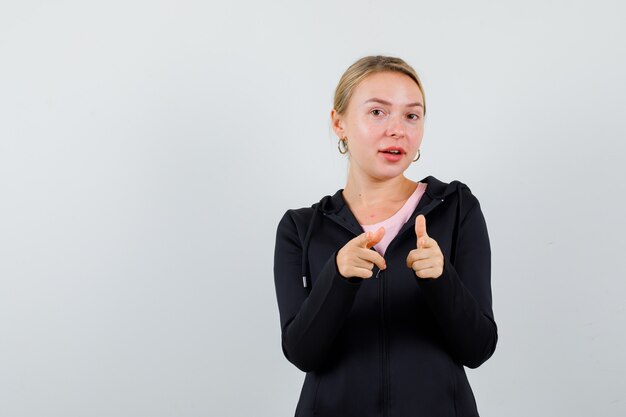 Jonge blonde vrouw in een zwarte jas