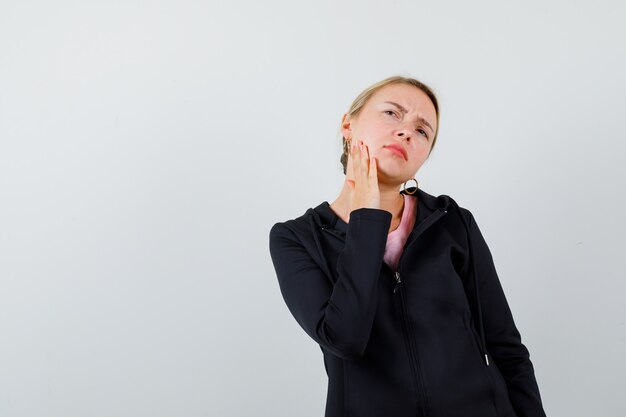 Jonge blonde vrouw in een zwarte jas