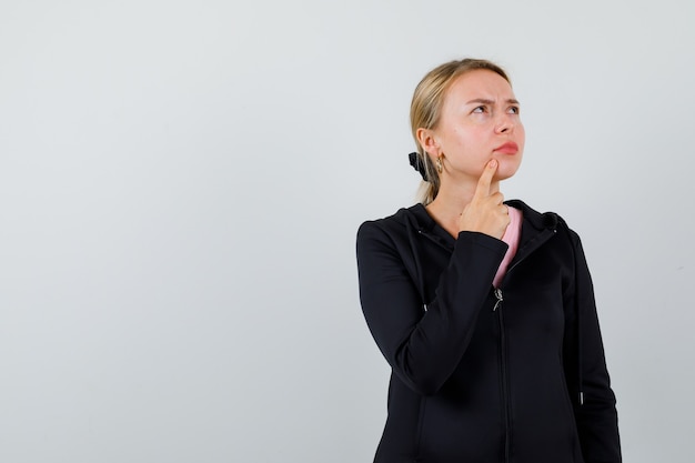 Jonge blonde vrouw in een zwarte jas