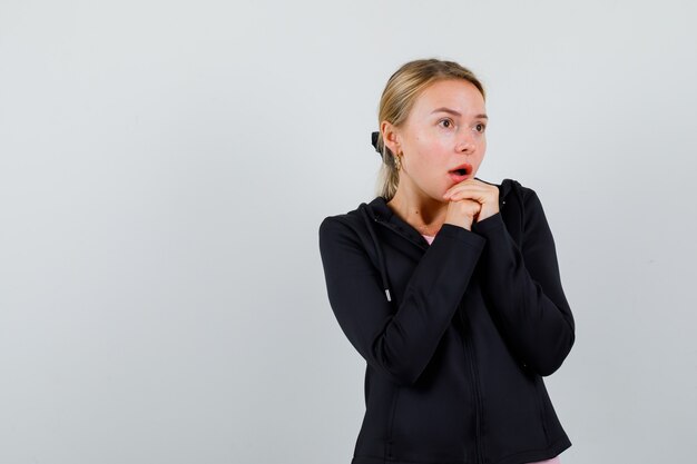 Jonge blonde vrouw in een zwarte jas