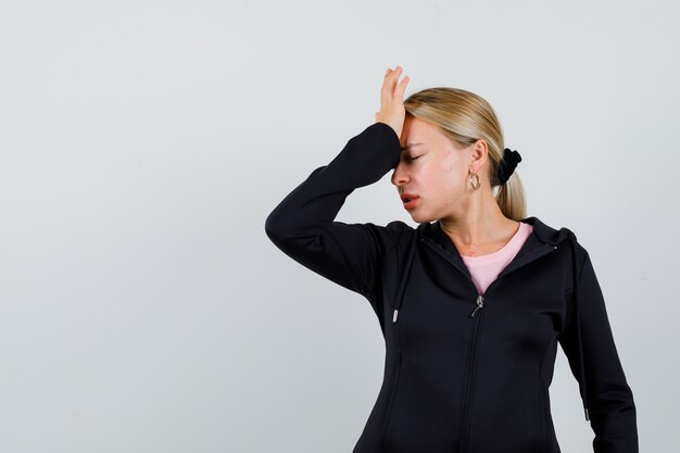 Jonge blonde vrouw in een zwarte jas