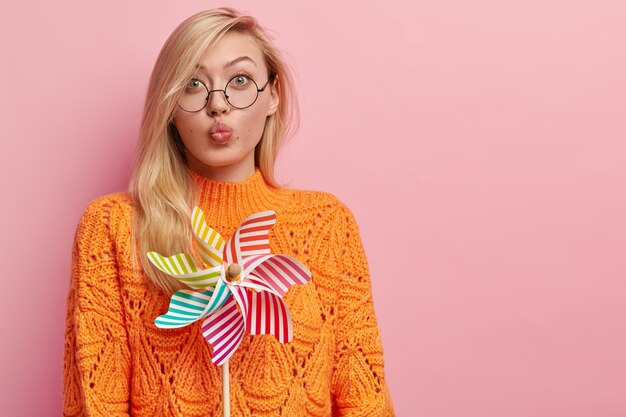 Gratis foto jonge blonde vrouw in oranje sweater