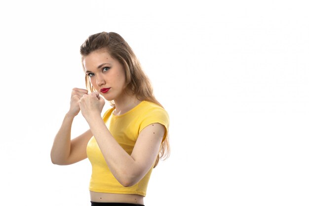 Jonge blonde vrouw met gele t-shirt wil vechten