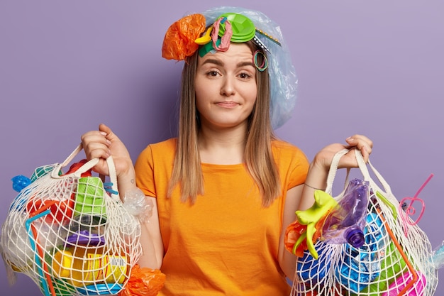 Jonge blonde vrouw poseren met plastic afval