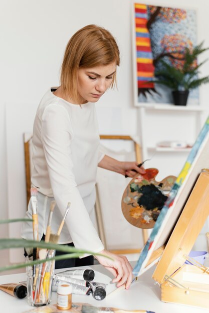 Jonge blonde vrouw schilderen met acrylverf