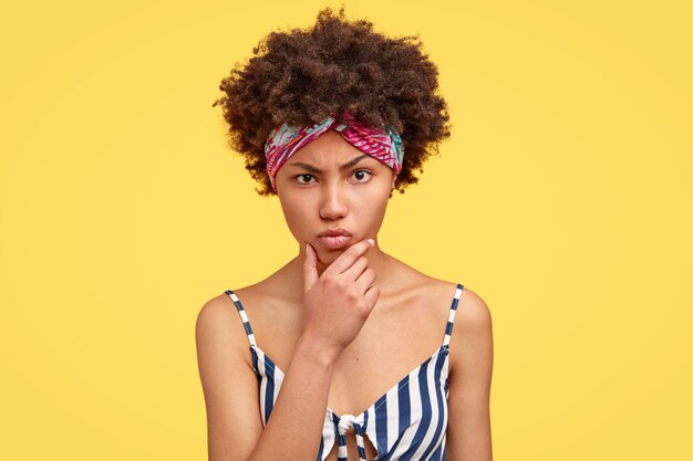 Jonge brunette vrouw met krullend haar en kleurrijke bandana