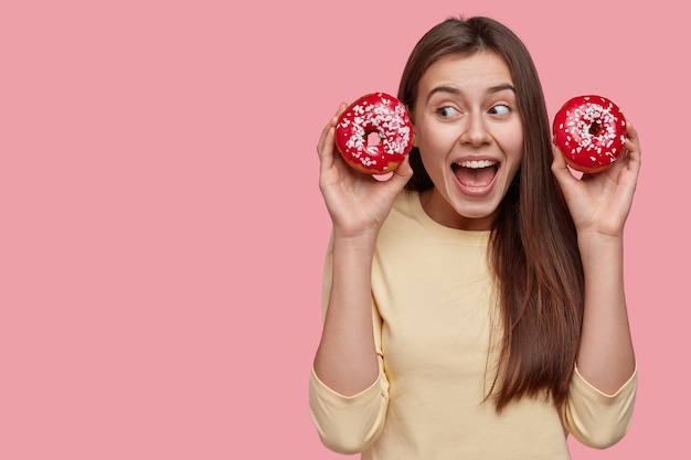 Jonge brunette vrouw met lekkere donuts