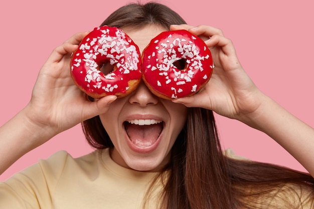 Jonge brunette vrouw met lekkere donuts