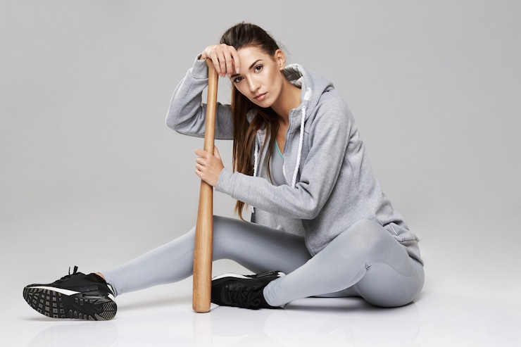 Gratis Foto jonge brute sportieve vrouw in sportkledingzitting met beetje op wit.