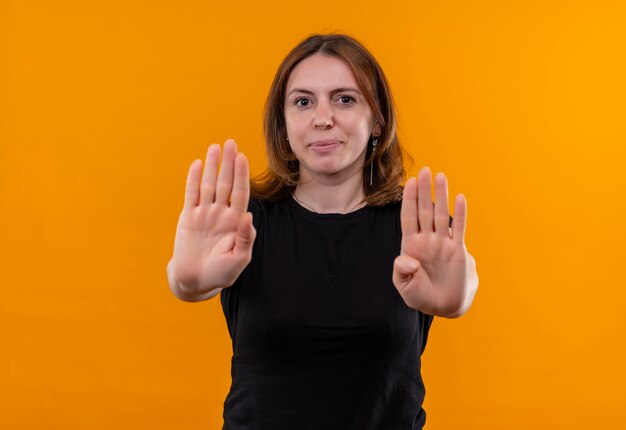 Jonge casual vrouw gebaren einde en kijken op geïsoleerde oranje muur met kopie ruimte