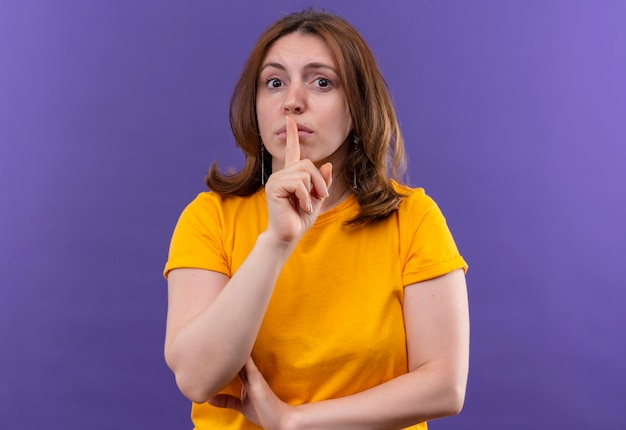 Jonge casual vrouw gebaren silece met vinger op mond op geïsoleerde paarse muur met kopie ruimte