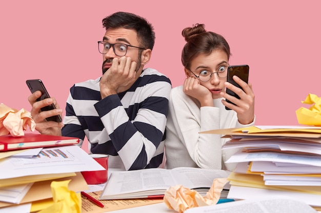 Jonge collega's die aan bureau met documenten zitten