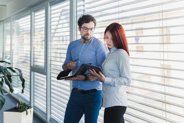 Jonge collega&#39;s werken met tablet en documenten