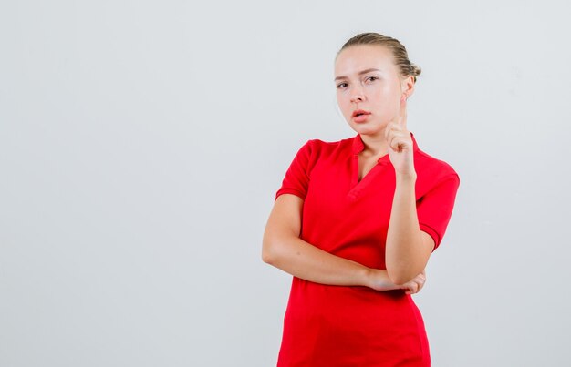 Jonge dame die benadrukt of waarschuwt in rood t-shirt en peinzend kijkt