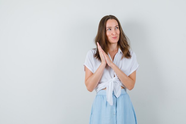 Jonge dame hand in hand samen in blouse, rok en op zoek dromerig