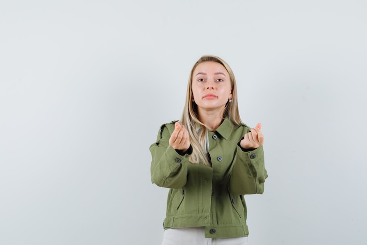 Gratis Foto jonge dame in jasje, broek doet geldgebaar, vooraanzicht.