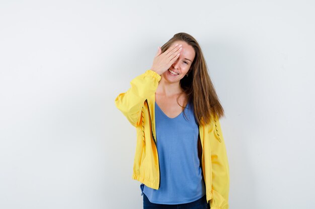 Jonge dame in t-shirt, jas hand in hand en ziet er mooi uit, vooraanzicht.