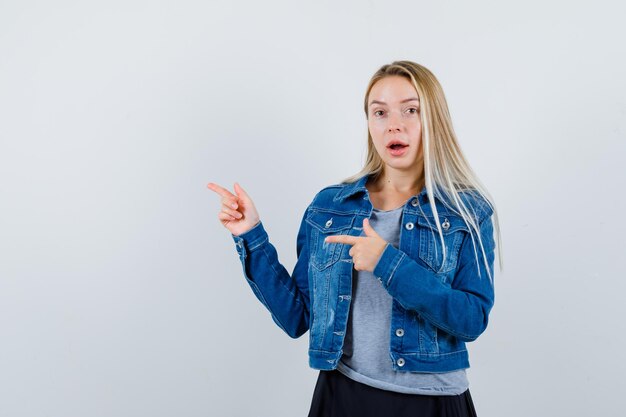 Jonge dame in t-shirt, spijkerjasje, rok opzij wijzend en verbaasd kijkend