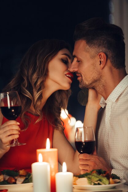 Jonge dame kust haar prachtige man tijdens een romantisch diner