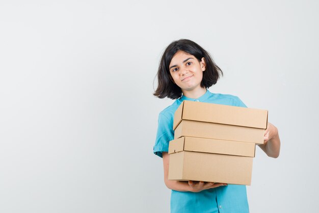 Jonge dame met dozen in blauw shirt en op zoek naar tevreden.