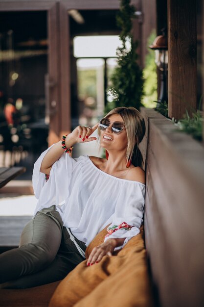 Jonge dame zittend in de bar