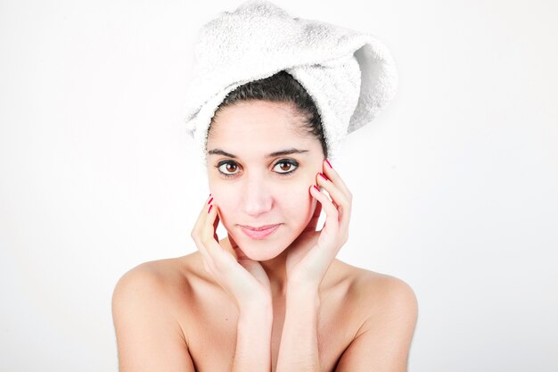 Jonge die vrouw met een handdoek rond haar hoofd tegen witte achtergrond wordt verpakt