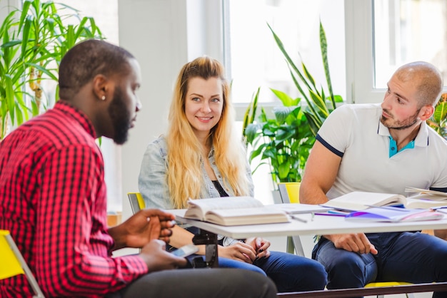 Gratis foto jonge diverse studenten bespreken ideeën